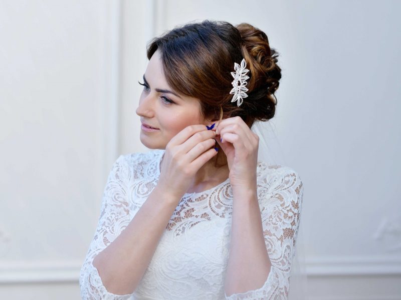 beautiful-bride-in-white-wedding-dress-puts-on-ear-PZCF8HN-1-scaled.jpg